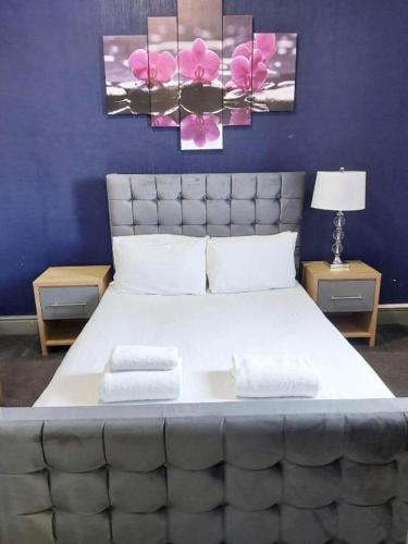 a bedroom with a large bed with pink flowers on the wall at OYO Ivy Hotel in Skegness