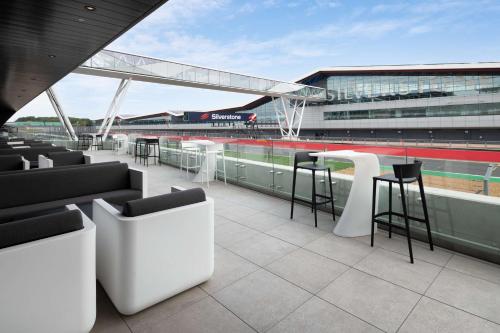 uma vista para um estádio de basebol com cadeiras e mesas em Hilton Garden Inn Silverstone em Towcester