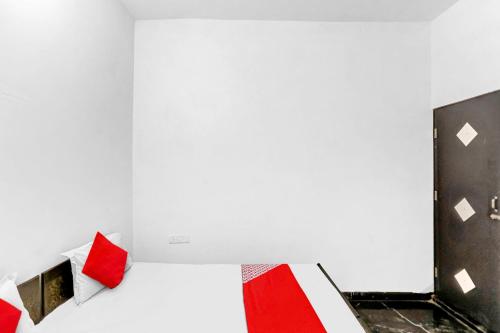 Pokój z łóżkiem z białymi i czerwonymi poduszkami w obiekcie OYO Flagship 81043 Paradise Inn w mieście Panchli