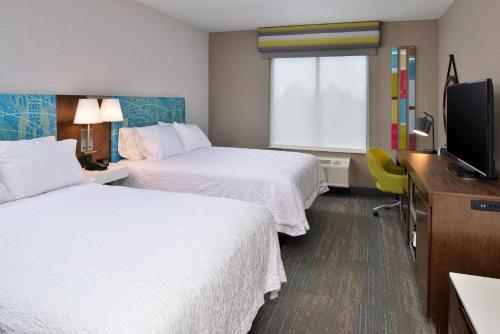 a hotel room with two beds and a flat screen tv at Hampton Inn & Suites Adrian, Mi in Adrian