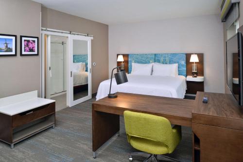 a hotel room with a bed and a desk with a computer at Hampton Inn & Suites Adrian, Mi in Adrian
