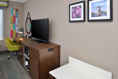 a room with a television and a desk with a chair at Hampton Inn & Suites Adrian, Mi in Adrian