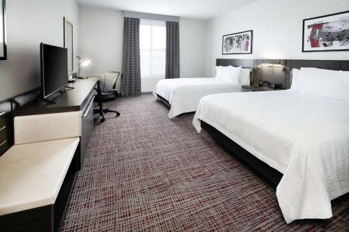 a hotel room with two beds and a flat screen tv at Hilton Garden Inn Irvine Spectrum Lake Forest in Lake Forest