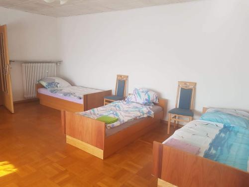 Habitación con 3 camas y 2 sillas en Pension Ehringshausen, en Ehringshausen