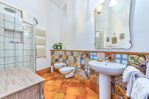 La salle de bains est pourvue d'un lavabo, de toilettes et d'un miroir. dans l'établissement Villa Aqvara, à Massa Lubrense