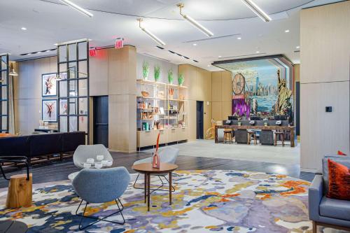 a lobby of a hotel with chairs and a table at Canopy By Hilton Jersey City Arts District in Jersey City