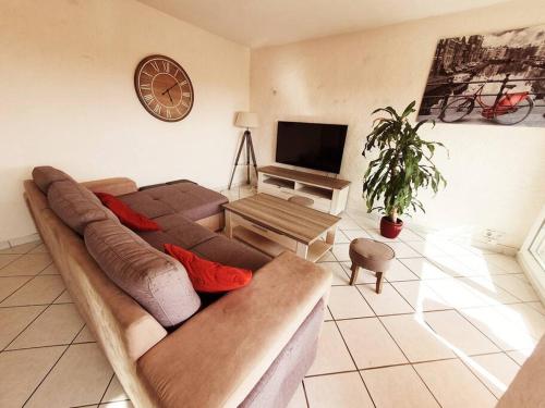 - un salon avec un grand canapé et une télévision dans l'établissement Appart 70m² plein sud, à Marignane