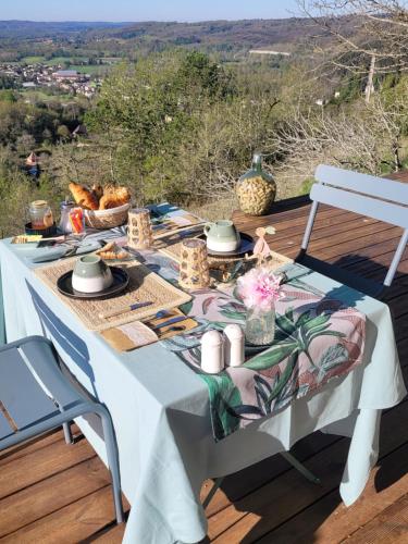 a table with food on top of a deck at le clos des etoiles B&B in Le Bugue