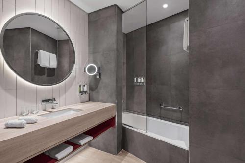 bagno con lavandino e specchio di Hampton by Hilton Marjan Island a Ras al Khaimah