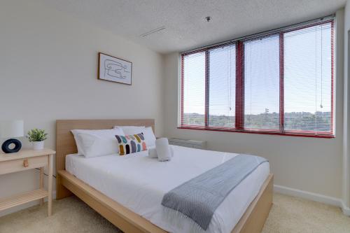 a bedroom with a large bed and a large window at Gorgeous Apt with Rooftop City View @Pentagon City in Arlington