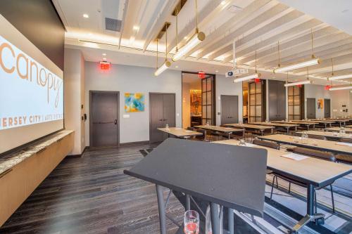 a dining room with tables and benches in it at Canopy By Hilton Jersey City Arts District in Jersey City