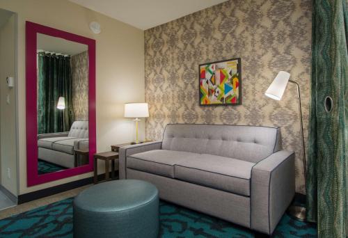 a living room with a couch and a mirror at Home2 Suites By Hilton Grove City Columbus in Grove City