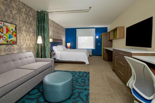 a hotel room with a bed and a couch at Home2 Suites By Hilton Grove City Columbus in Grove City