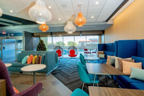 a lobby with blue couches and tables and colorful chairs at Tru By Hilton The Colony in The Colony