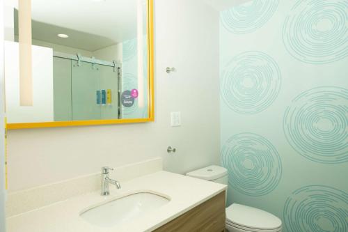 a bathroom with a sink and a toilet and a mirror at Tru By Hilton The Colony in The Colony