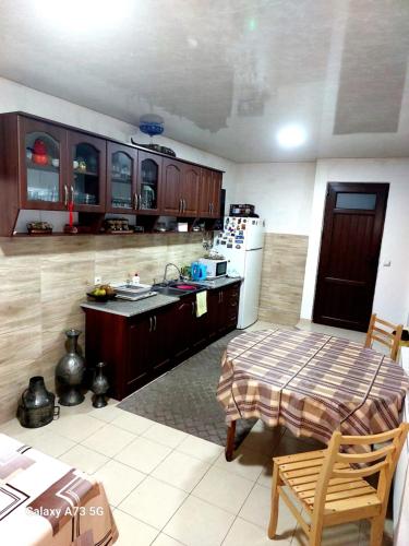 een keuken met een tafel en een koelkast bij guest house lela rezo in Kazbegi