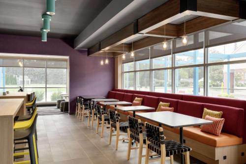 a restaurant with tables and chairs and windows at Tru By Hilton Sandusky, Oh in Sandusky