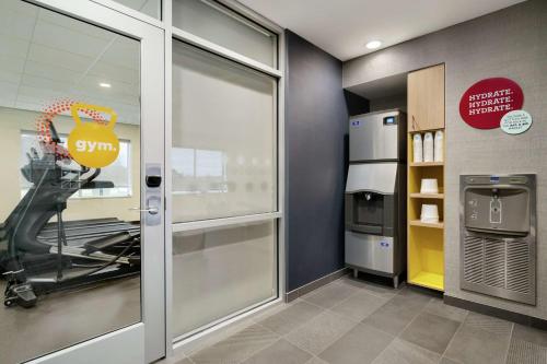 a gym with a treadmill and a glass door at Tru By Hilton Sandusky, Oh in Sandusky