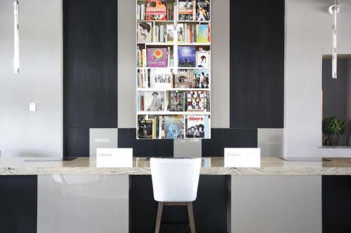 a kitchen with a counter with two white chairs at The Rewind West Des Moines, Tapestry Collection By Hilton in West Des Moines
