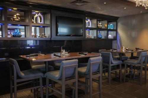 a restaurant with two tables and chairs and a television at The Rewind West Des Moines, Tapestry Collection By Hilton in West Des Moines