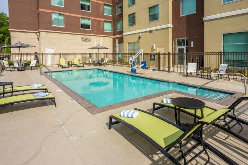 a large swimming pool with chairs and tables at Hilton Garden Inn Memphis East/Germantown, Tn in Memphis