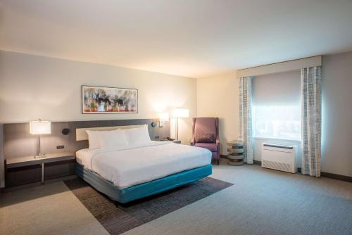 a hotel room with a bed and a chair at Hilton Garden Inn Memphis East/Germantown, Tn in Memphis