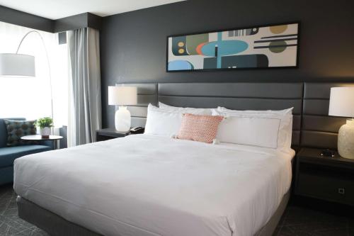 um quarto com uma grande cama branca e um sofá em The Rewind West Des Moines, Tapestry Collection By Hilton em West Des Moines