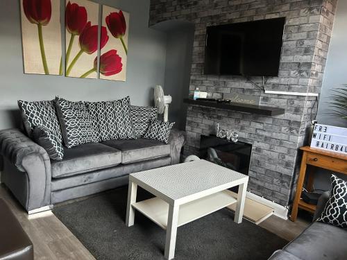 sala de estar con sofá y chimenea en WV1 Bridge House - 3 Bedrooms, sleeps 6 free Parking - New Cross - Bentley Bridge - 欢迎, en Wolverhampton