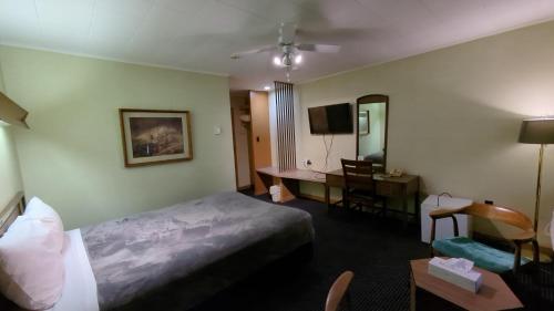 Habitación de hotel con cama y escritorio en Mariner motor hotel en Collingwood