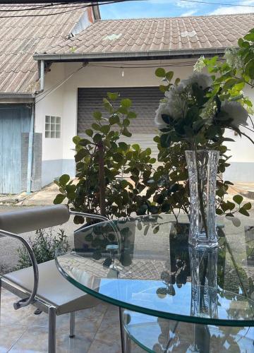 a glass table with a vase with flowers on it at Rynn in Trat