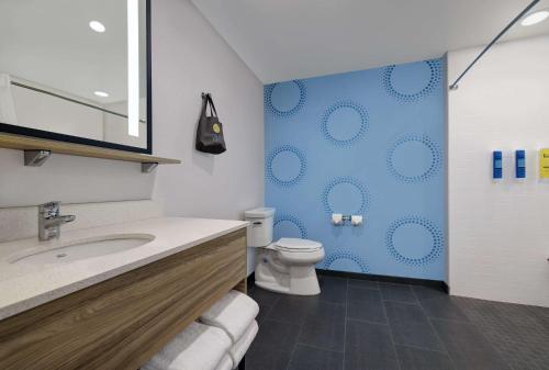 a bathroom with a toilet and a blue wall at Tru By Hilton Tukwila Seattle Airport, Wa in Tukwila