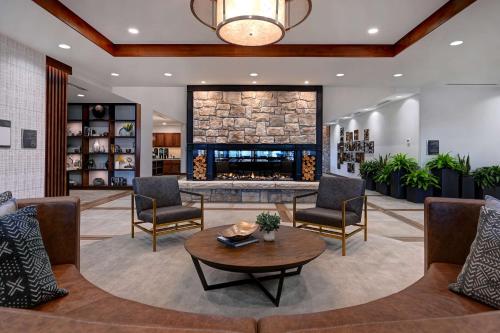 a lobby with a fireplace and chairs and a table at Homewood Suites By Hilton Eagle Boise, Id in Eagle