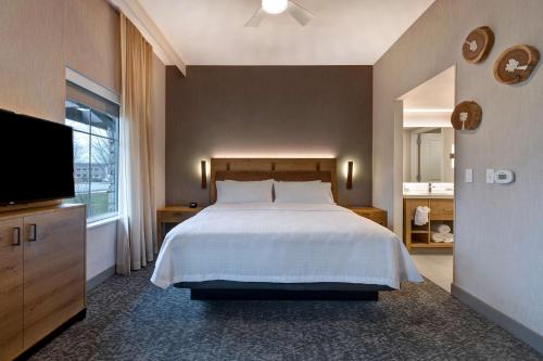 a bedroom with a bed and a flat screen tv at Homewood Suites By Hilton Eagle Boise, Id in Eagle