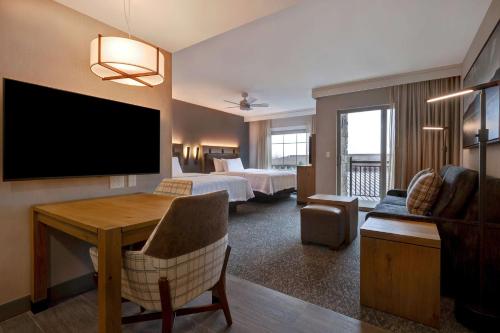 a hotel room with a bedroom with a bed and a desk at Homewood Suites By Hilton Eagle Boise, Id in Eagle