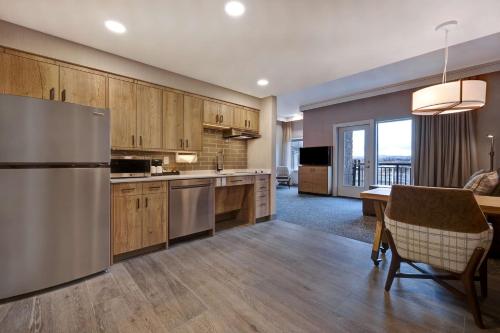 a kitchen with a stainless steel refrigerator and a table at Homewood Suites By Hilton Eagle Boise, Id in Eagle