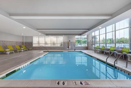 ein Pool in einem Hotel mit Stühlen in der Unterkunft Hilton Garden Inn Manassas in Manassas