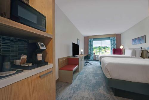 a hotel room with a bed and a television at Hilton Garden Inn Manassas in Manassas