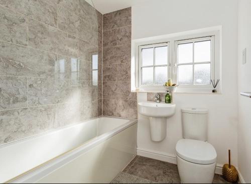 uma casa de banho com um WC, uma banheira e um lavatório. em Abbot House em Manchester