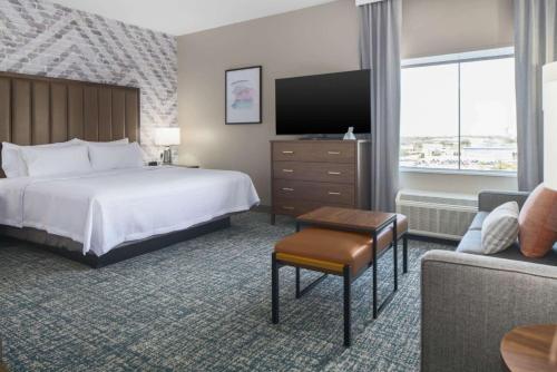 a hotel room with a bed and a couch at Homewood Suites by Hilton DFW Airport South, TX in Fort Worth