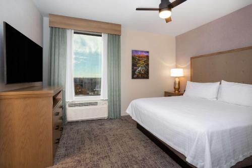 a bedroom with a bed and a large window at Homewood Suites By Hilton Albuquerque Downtown in Albuquerque