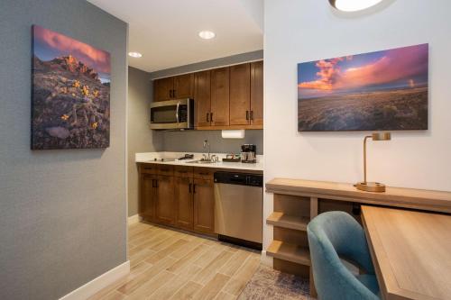 a kitchen with wooden cabinets and a counter top at Homewood Suites By Hilton Albuquerque Downtown in Albuquerque