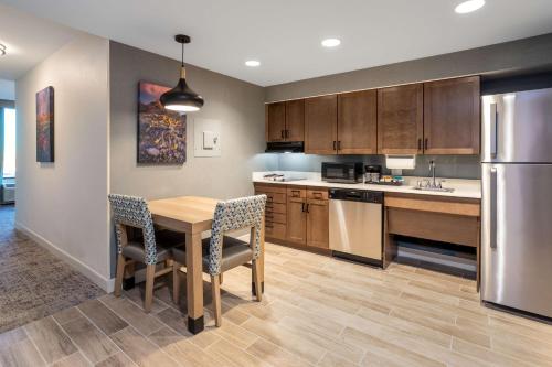 a kitchen with a table and chairs and a refrigerator at Homewood Suites By Hilton Albuquerque Downtown in Albuquerque