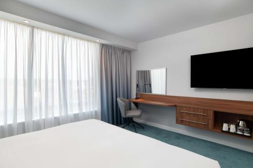 a hotel room with a bed and a flat screen tv at Hampton by Hilton Canterbury in Canterbury