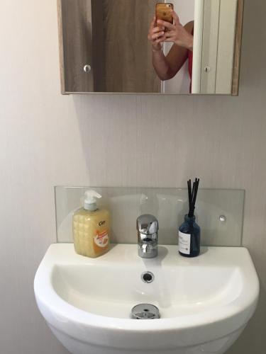 a woman taking a picture of a bathroom sink at 3 bedroom Heaven Home in Chichester