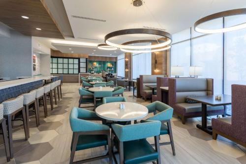 a restaurant with tables and chairs and a bar at Hilton Garden Inn Albuquerque Downtown, Nm in Albuquerque