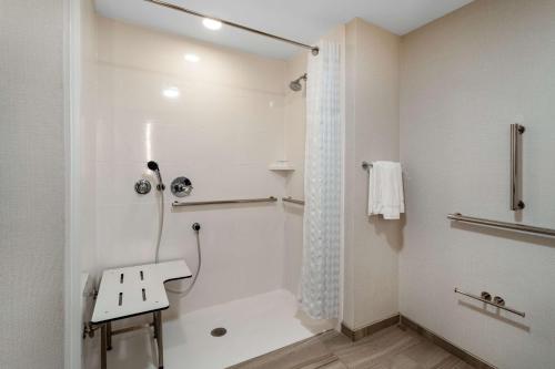 a white bathroom with a shower and a sink at Hilton Garden Inn Albuquerque Downtown, Nm in Albuquerque
