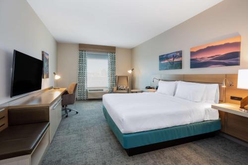 um quarto de hotel com uma cama e uma secretária em Hilton Garden Inn Albuquerque Downtown, Nm em Albuquerque