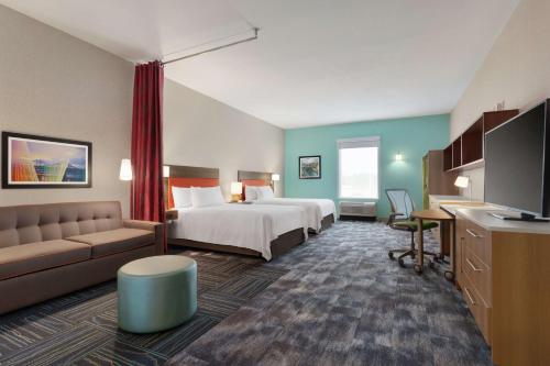 ヴィックスバーグにあるHome2 Suites By Hilton Vicksburg, Msのベッドとソファ付きのホテルルーム