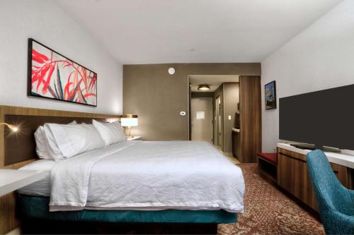 a hotel room with a bed and a flat screen tv at Hilton Garden Inn Bel Air, Md in Bel Air