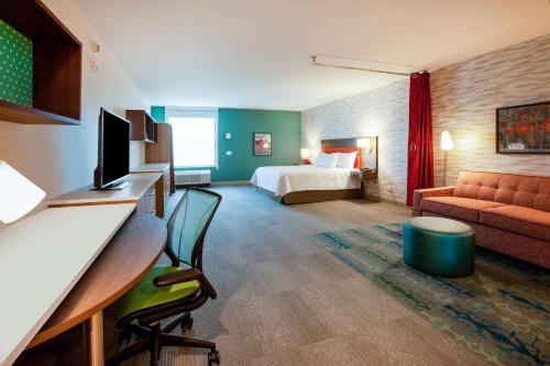 um quarto de hotel com uma cama e um sofá em Home2 Suites By Hilton Bloomington Normal em Normal